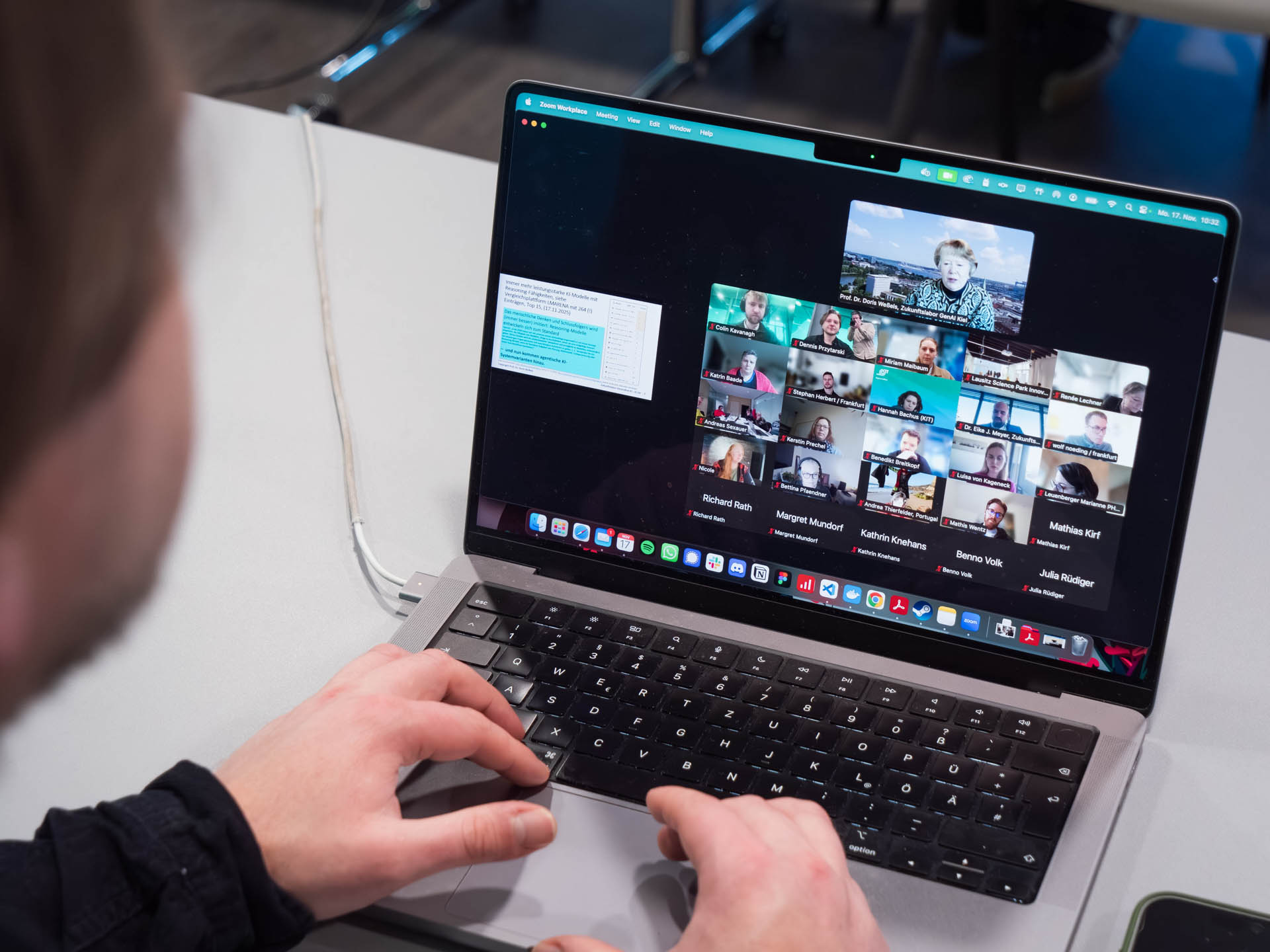 Blick über die Schulter eines Teilnehmenden: Auf dem Laptop sind die Zoom-Kacheln der weiteren Teilehmenden zu sehen.